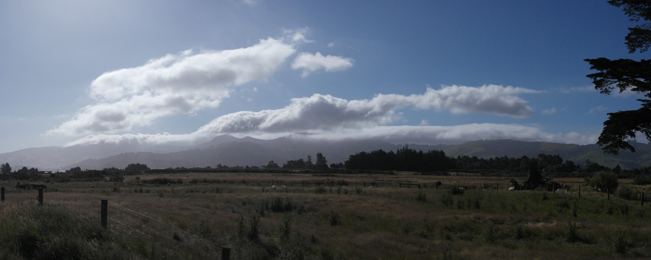 Coole Wolkenformationen wälzen sich über die an Dunedin angrenzenden Berge 